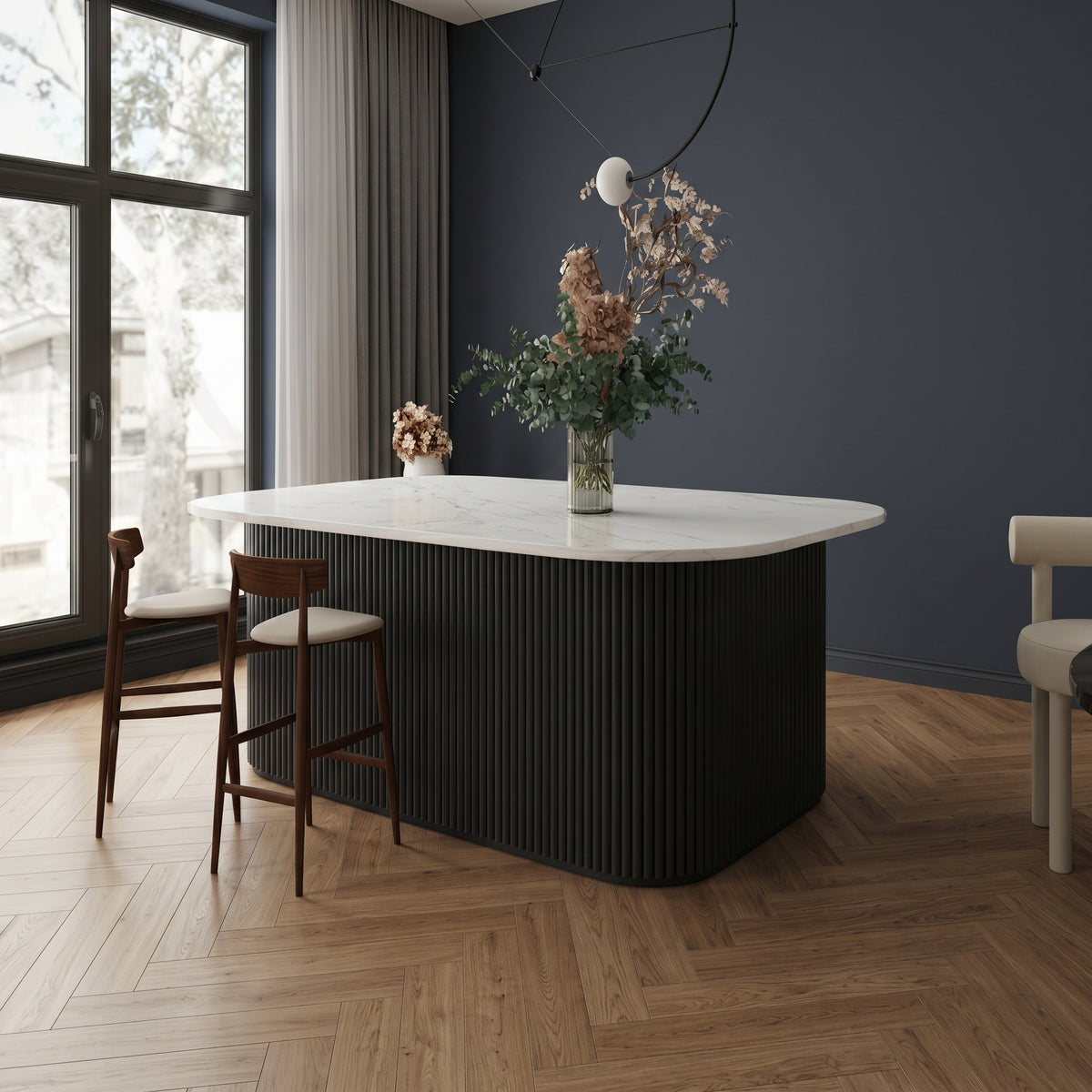 Black flexible fluted reeded acoustic tambour panel wrapped around a curved island counter, dark navy wall