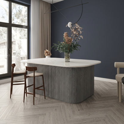 Grey flexible fluted reeded acoustic tambour panel wrapped around a curved island counter, navy wall