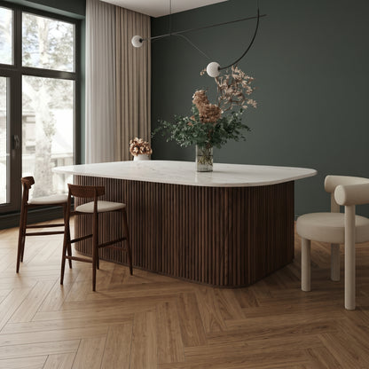 Walnut flexible fluted reeded acoustic tambour panel wrapped around a curved island counter, dark green wall